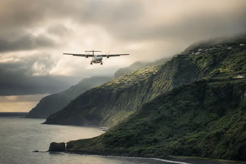 Avião regional de turbo-hélice em aproximação a uma ilha atlântica portuguesa